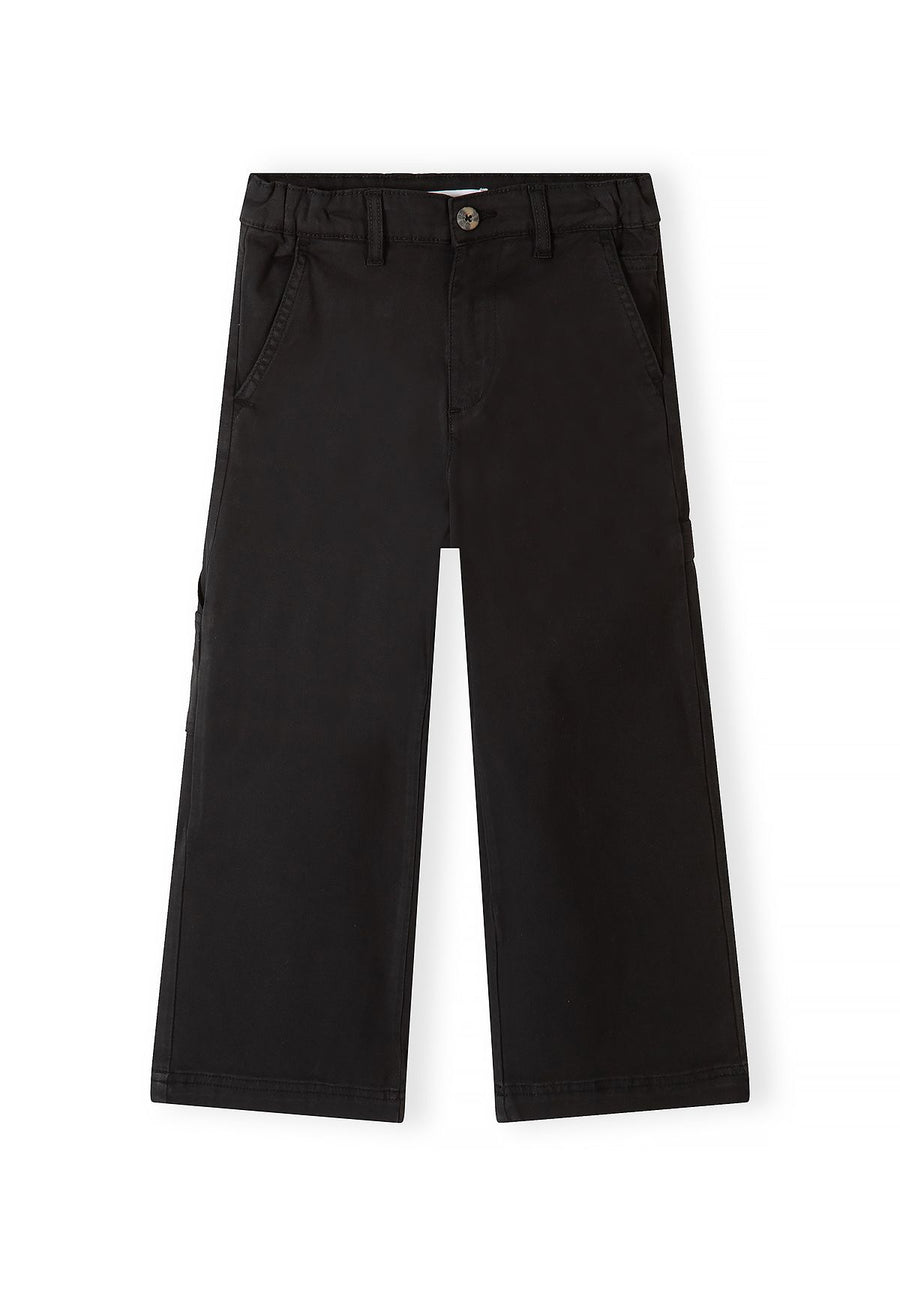 Front of black carpenter trousers with button waist and slanted pockets.