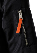 Close-up view of the black girls longline parka jacket fur trim hood featuring a functional orange zipper detail. 3-14y.