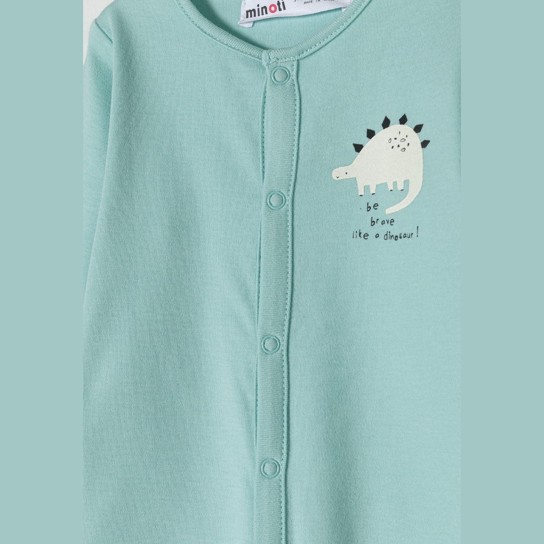 Close-up of mint sleepsuit front showing white dinosaur graphic and be brave text