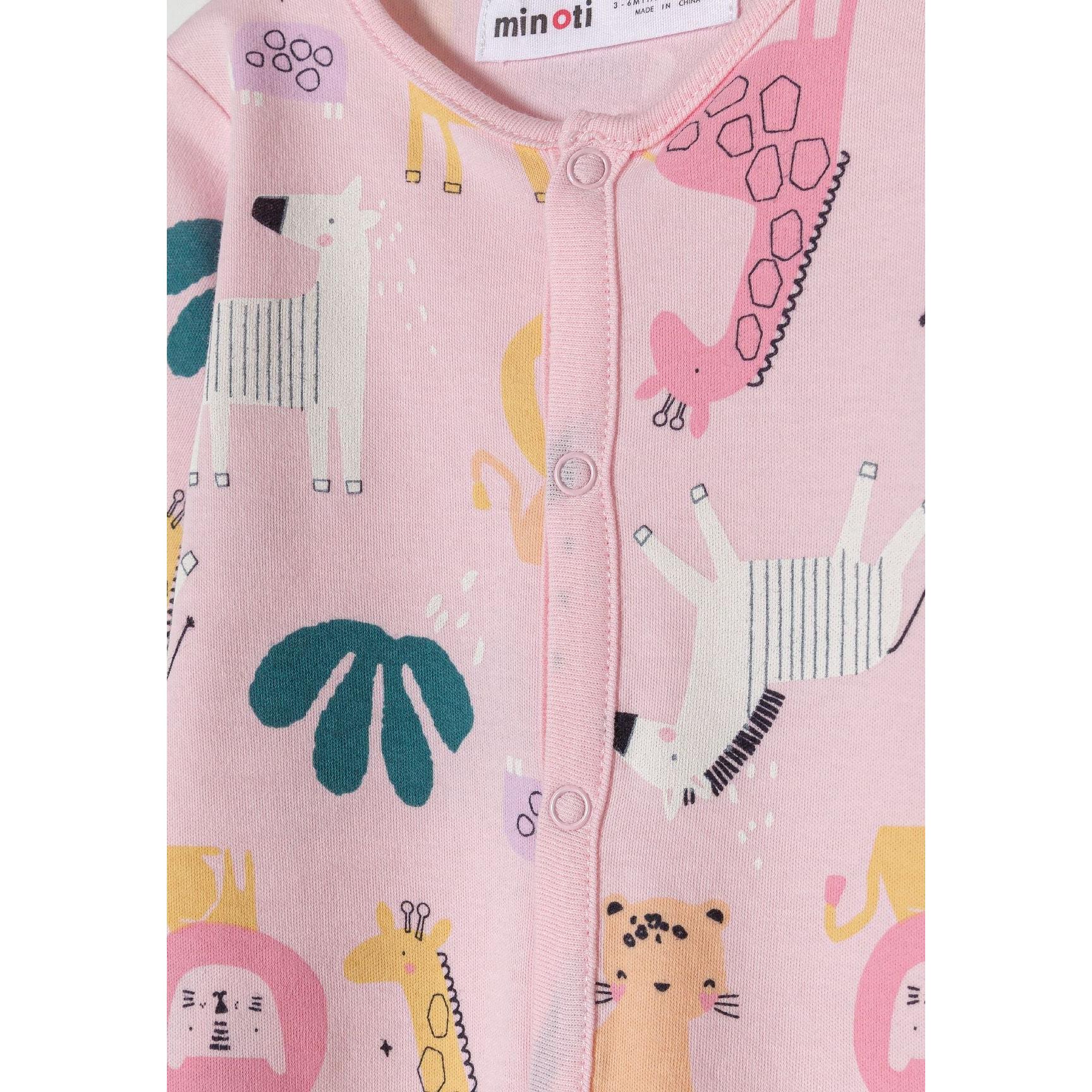 Close-up detail of pink sleepsuit showing snap button closure, Minoti label and jungle animal print with giraffe and leaf motifs