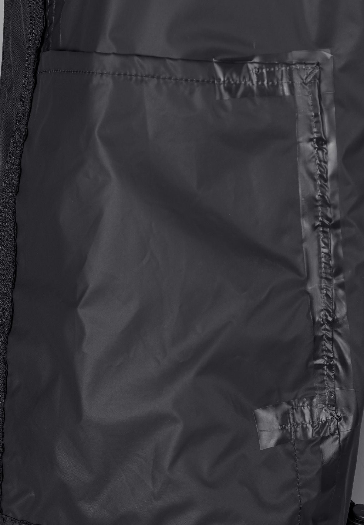 Close-up of the inside placket on the black packaway hooded jacket.