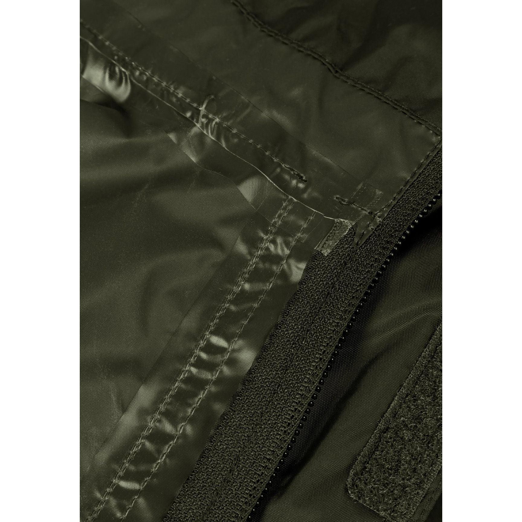 Close-up detail of khaki jacket side showing zip pocket with branded zipper pull and seam construction against white background