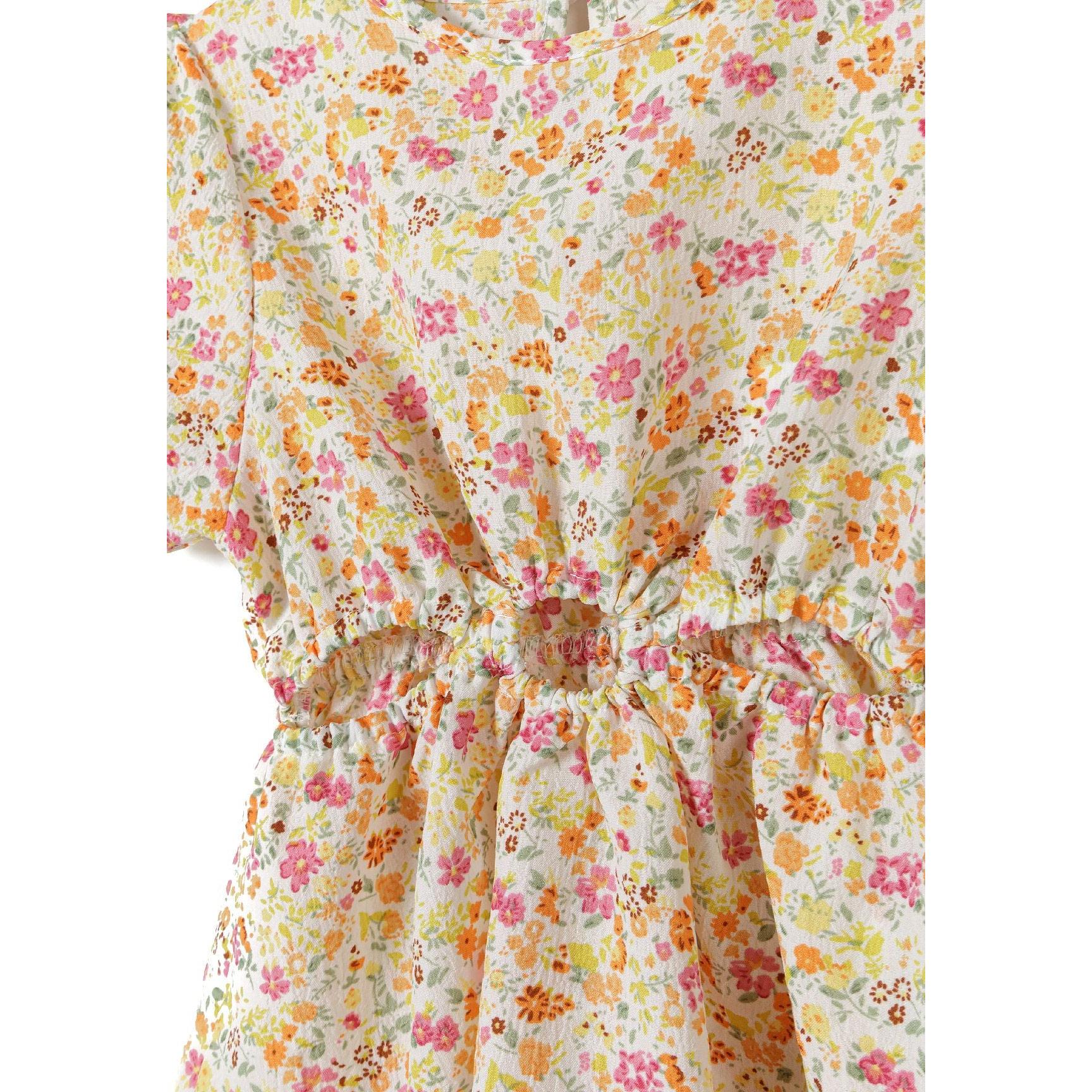 Close-up detail of yellow floral crinkle fabric showing tiny flowers in pink, orange and white with gathered waist tie detail