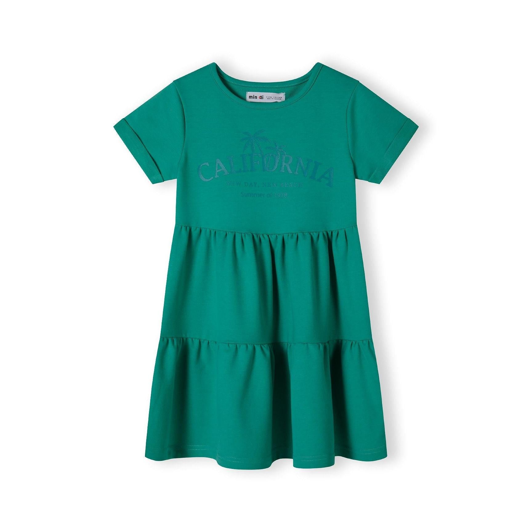 Back view of green tiered cotton dress laid flat showing short sleeves and three-tier ruffle design on white background