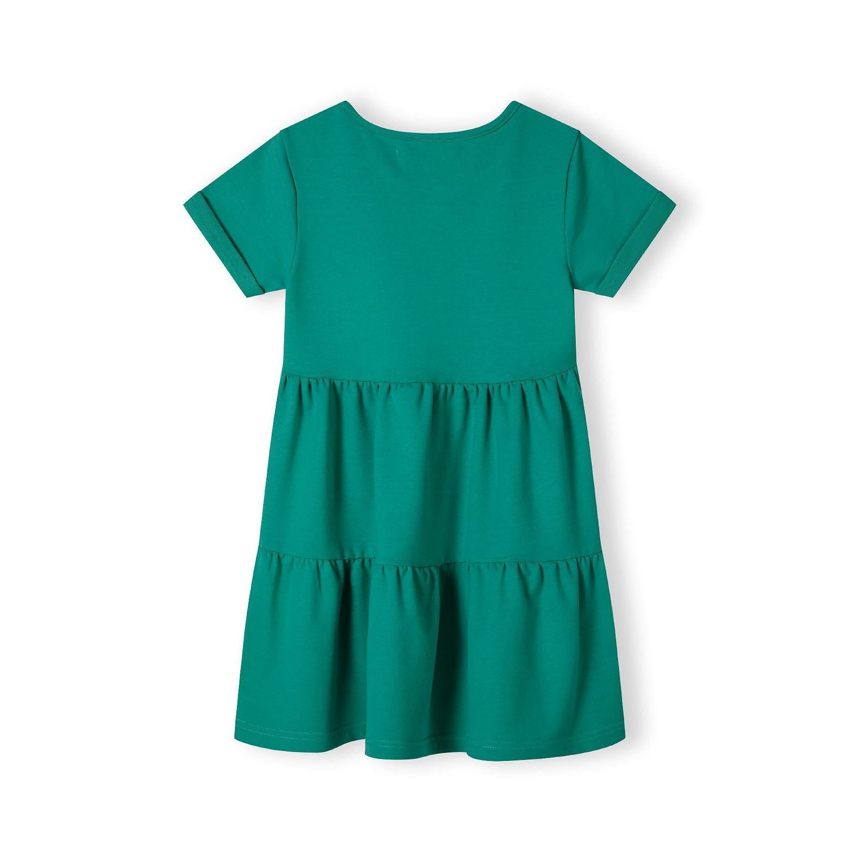 Back view of green tiered cotton dress laid flat showing short sleeves and three-tier ruffle design on white background