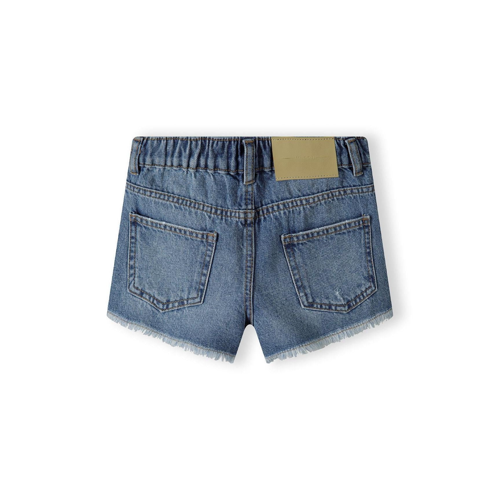 Back view of navy denim shorts showing frayed hem detail, classic five-pocket construction and branded label patch on flat surface