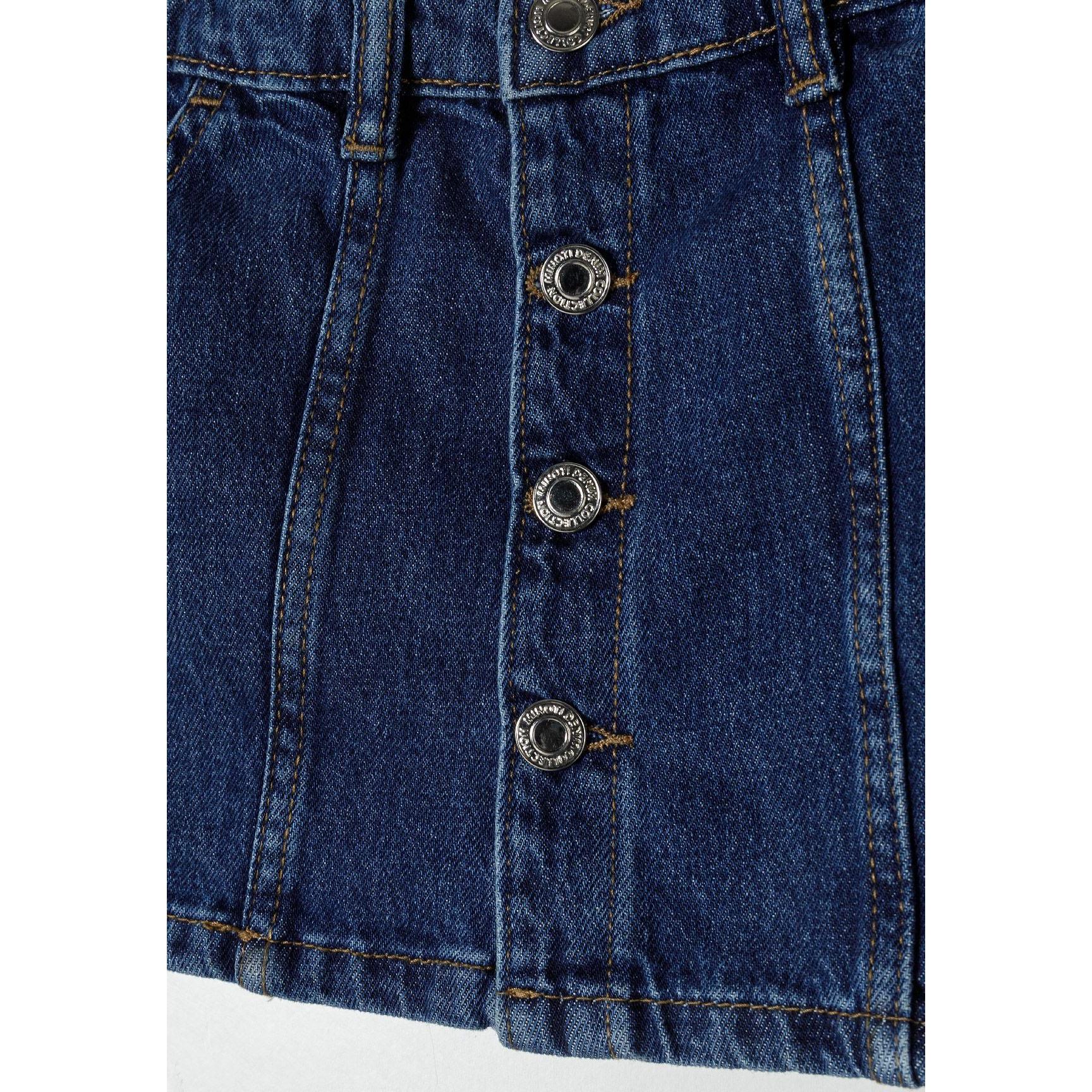 Close-up detail of decorative metal buttons on navy denim skirt showing button closure design