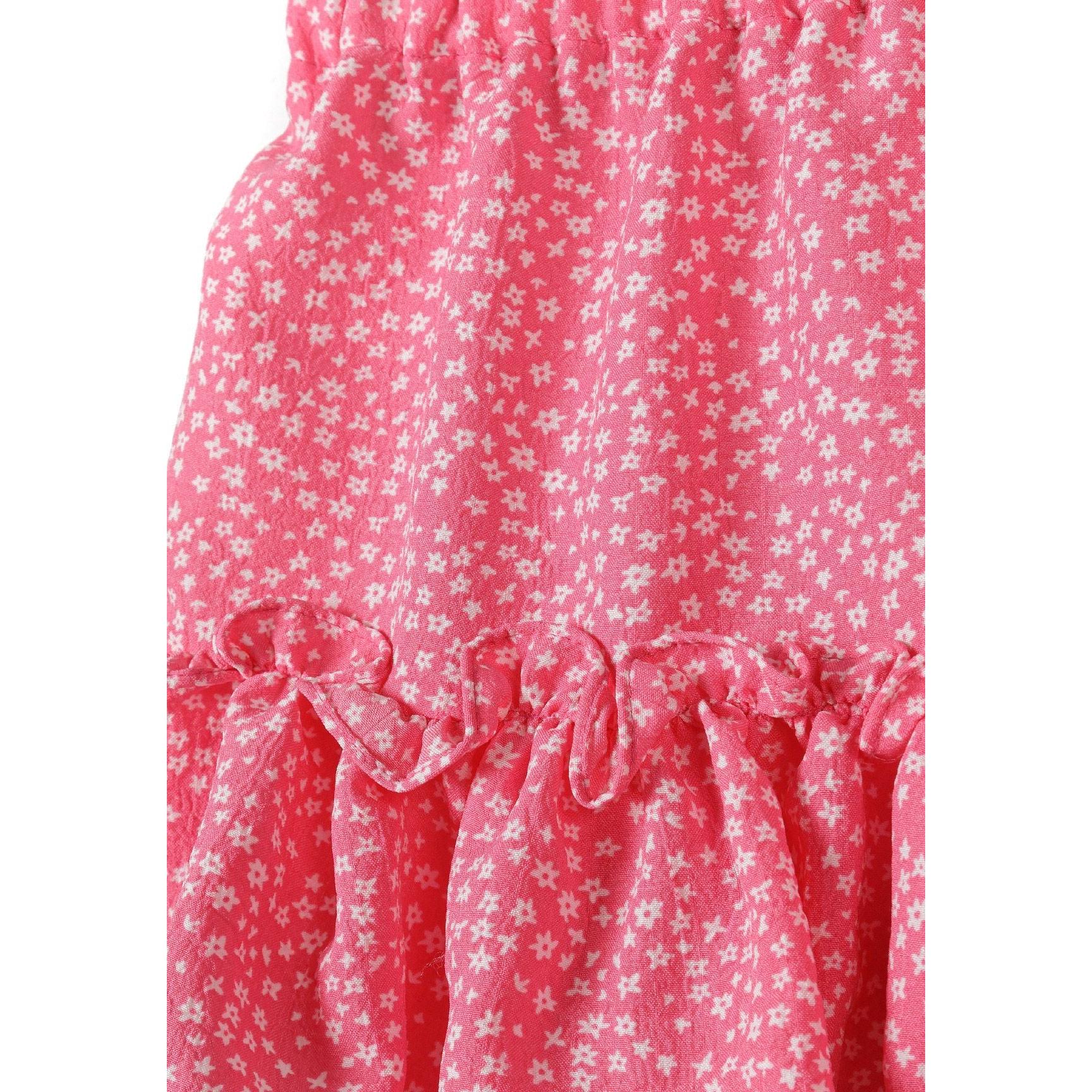Close-up detail of pink crinkle fabric with small white floral pattern showing texture and ruffle construction of the layered skirt
