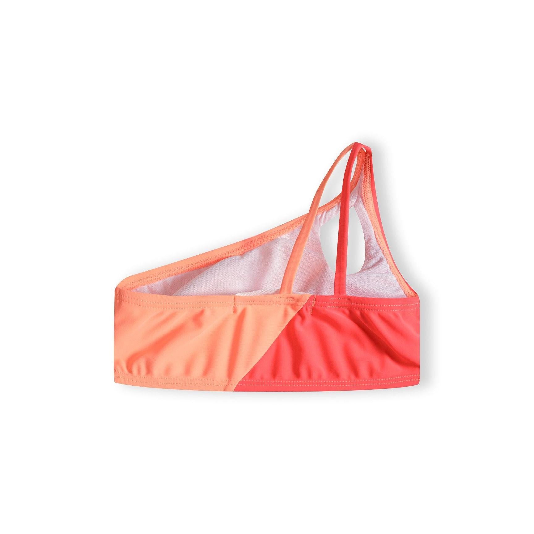 Close-up view of asymmetric bikini top showing one-shoulder design and colour-block pattern in apricot and coral on white background