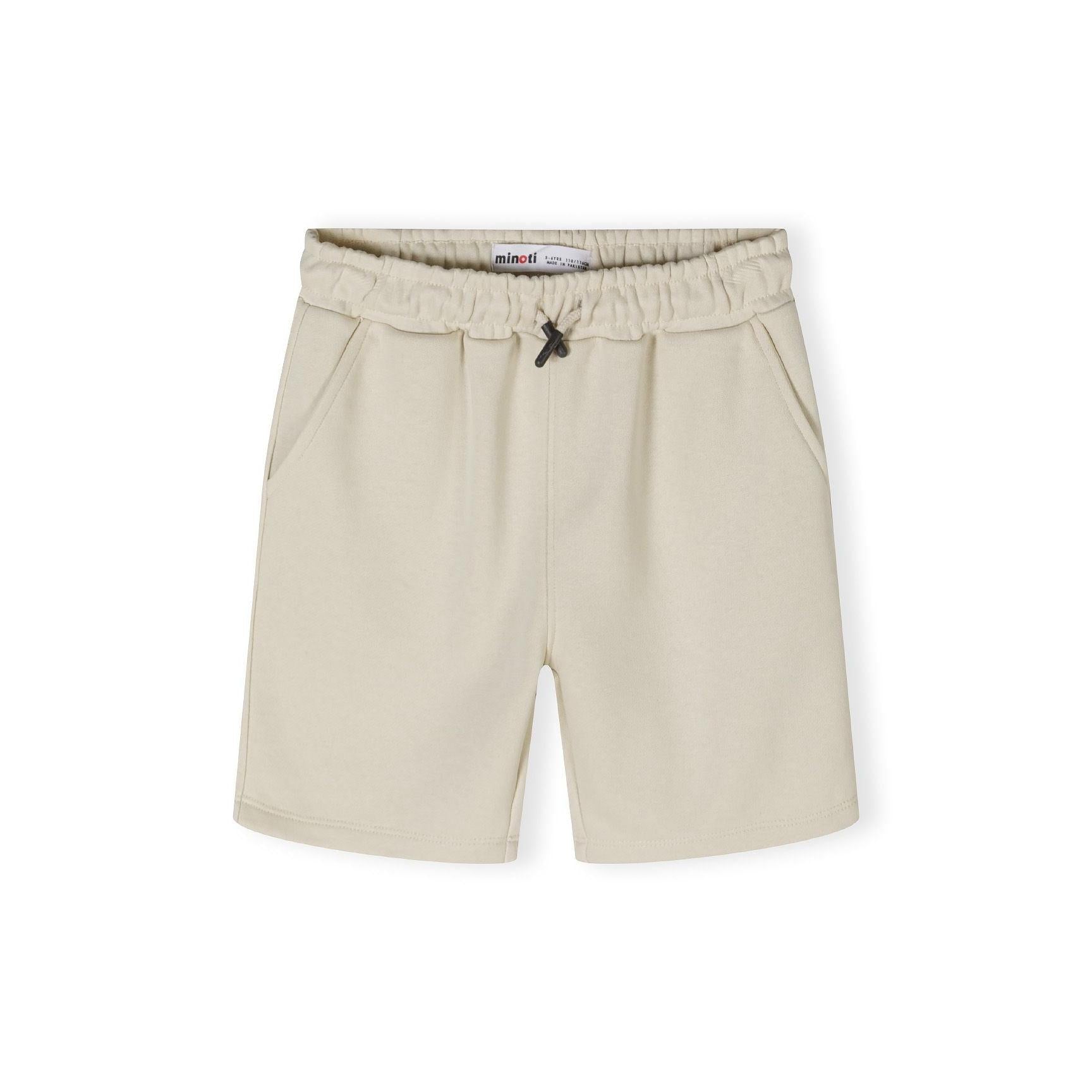 Close-up detail of beige shorts waistband showing elasticated fabric and black drawstring toggle