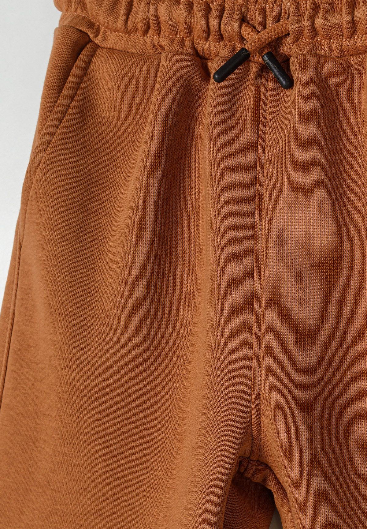 Rust brown vest and shorts set, waist detail.