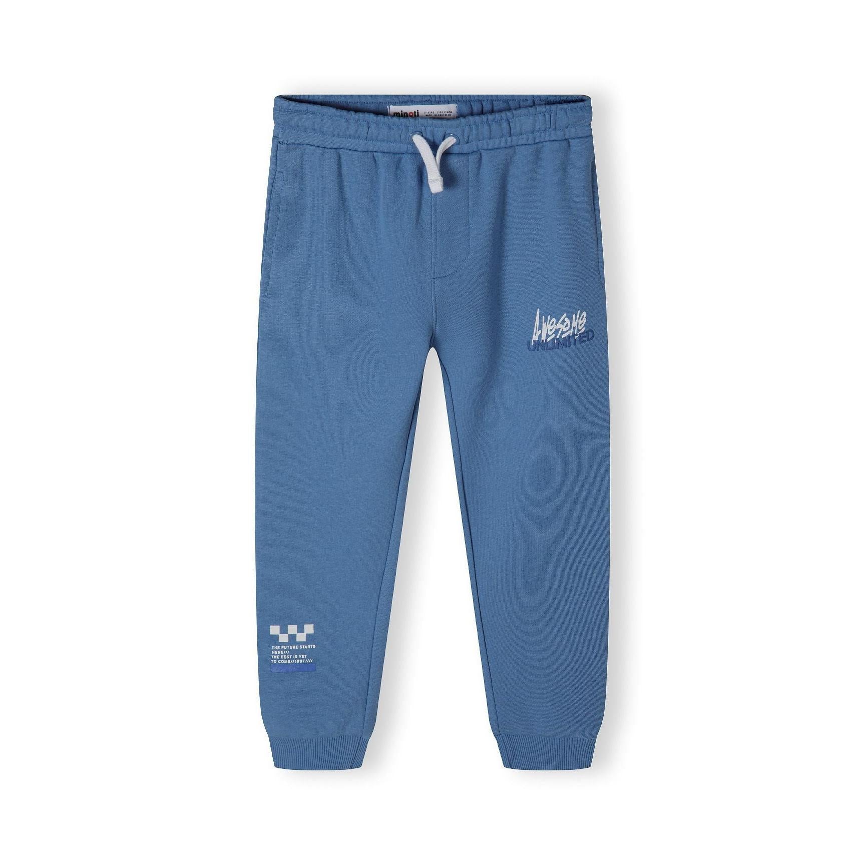 Close-up detail of blue joggers showing white 'Awesome Unlimited' text graphics on the leg