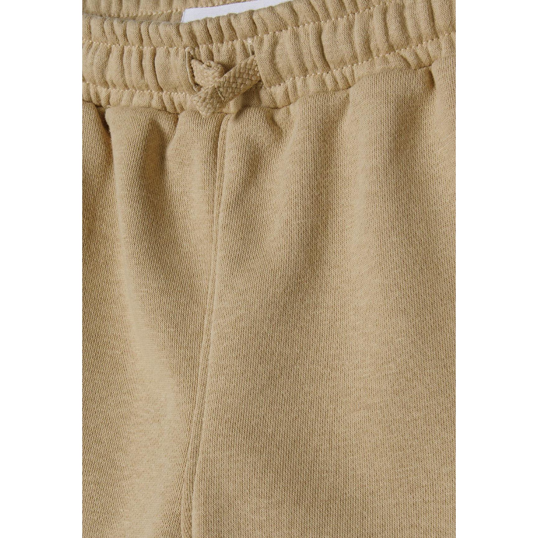 Close-up detail of beige fleece shorts waistband showing elasticated band with woven drawstring tie