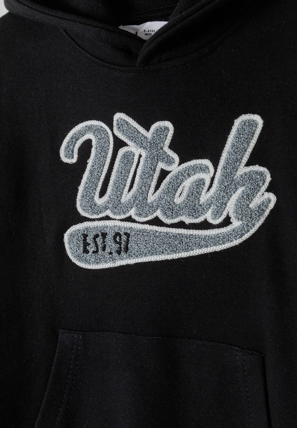 Black pullover hoodie, lettering detail.