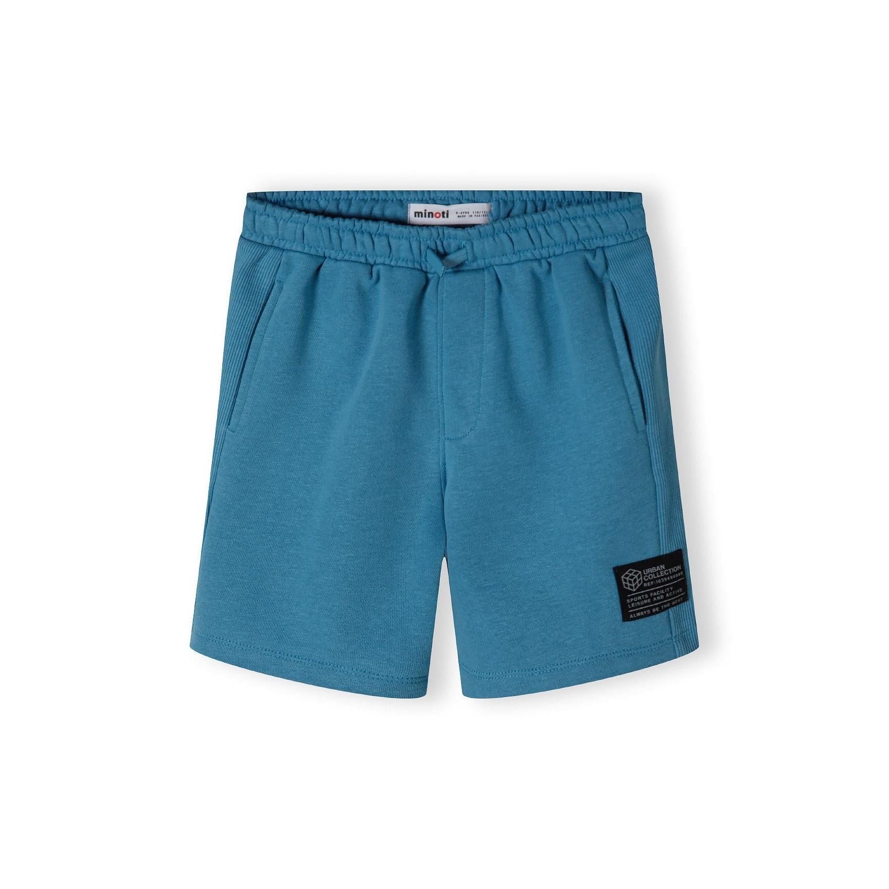 Blue fleece shorts laid flat showing front view with elastic waistband and relaxed cut design