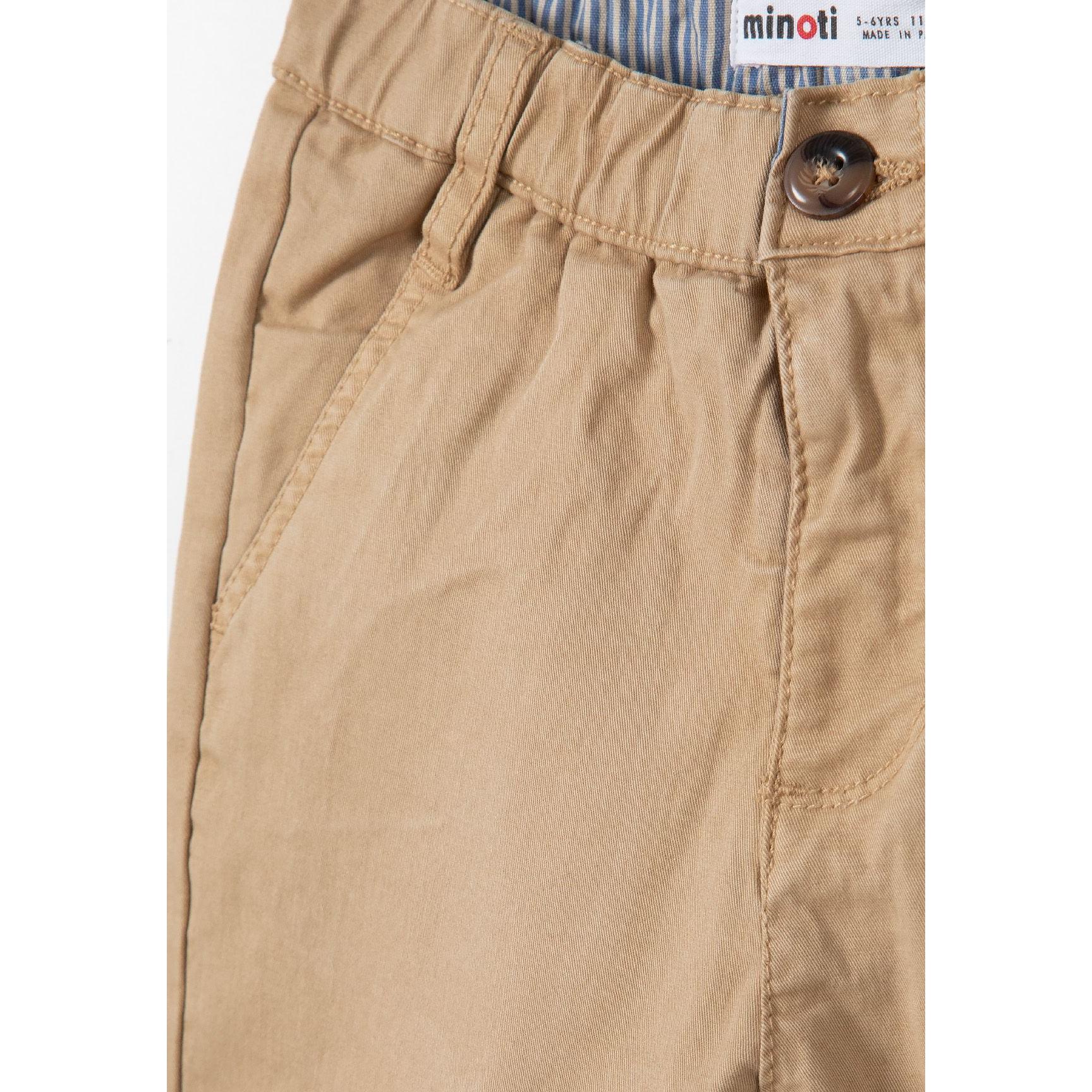 Close-up detail of stone beige chino shorts showing Minoti label, button closure and pocket construction
