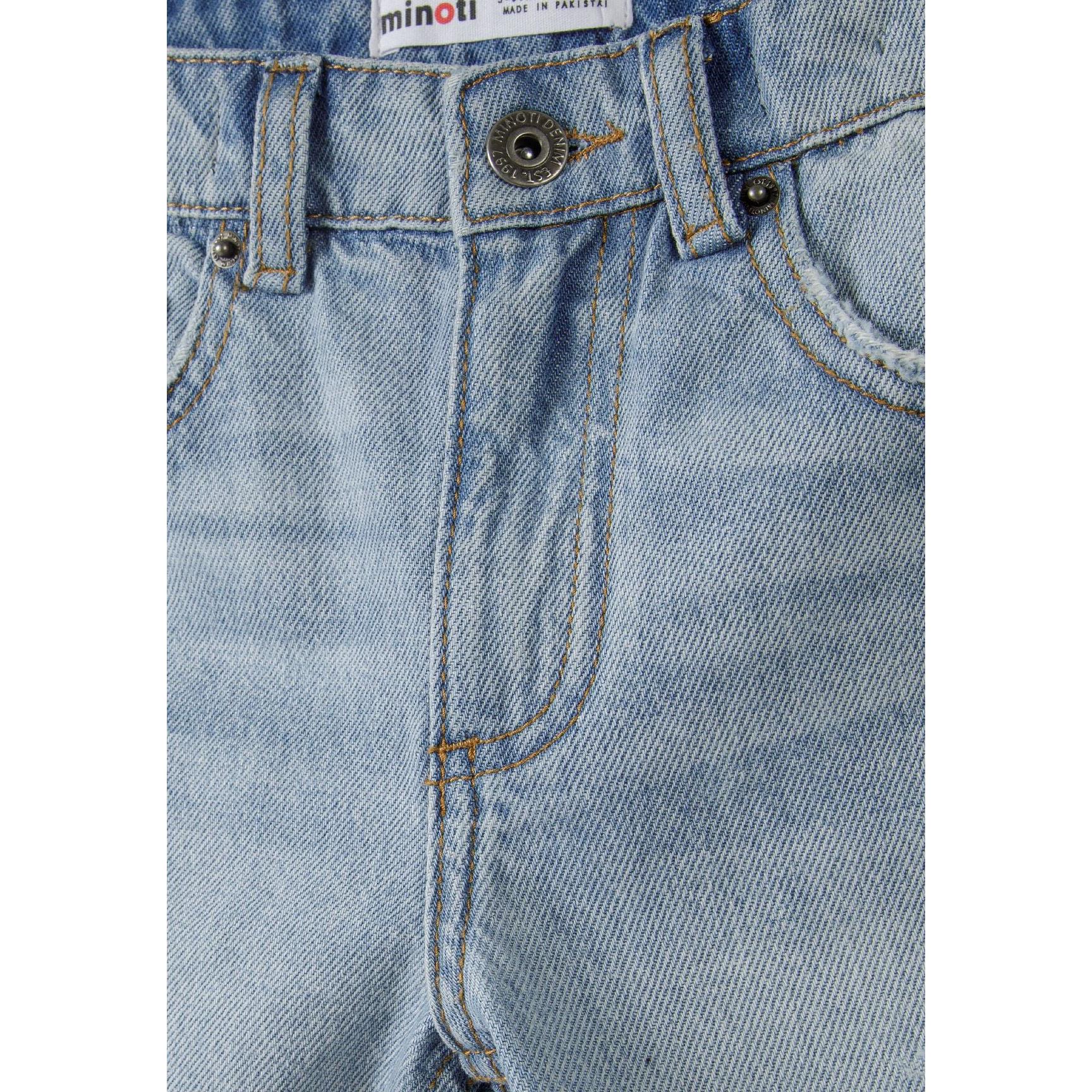Close-up detail of light blue denim shorts showing Minoti brand label, button closure and front pocket construction