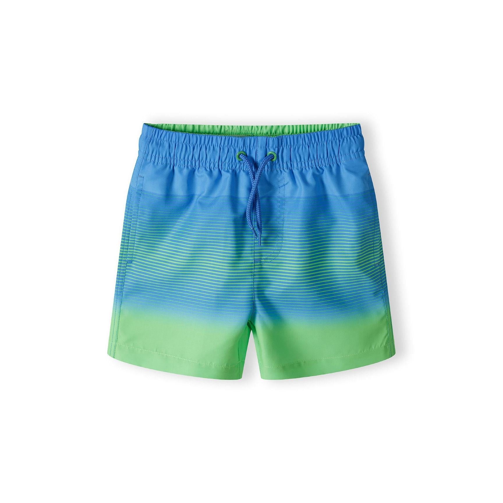 Blue to green gradient board shorts laid flat against white background showing full design and colour transition
