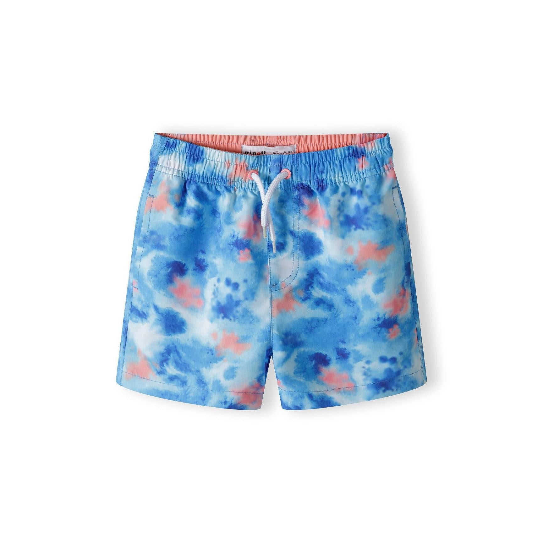 Blue tie-dye swim shorts with coral trim waistband laid flat on white background showing vibrant all-over print pattern