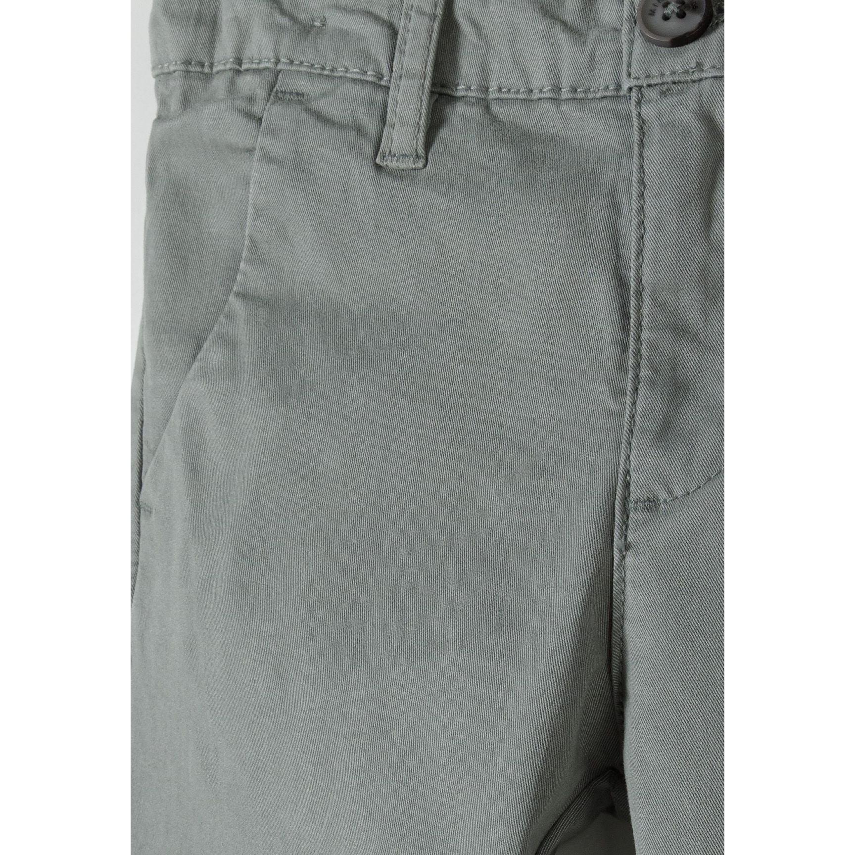 Close-up detail of grey chino trouser waistband showing button closure and front pocket construction