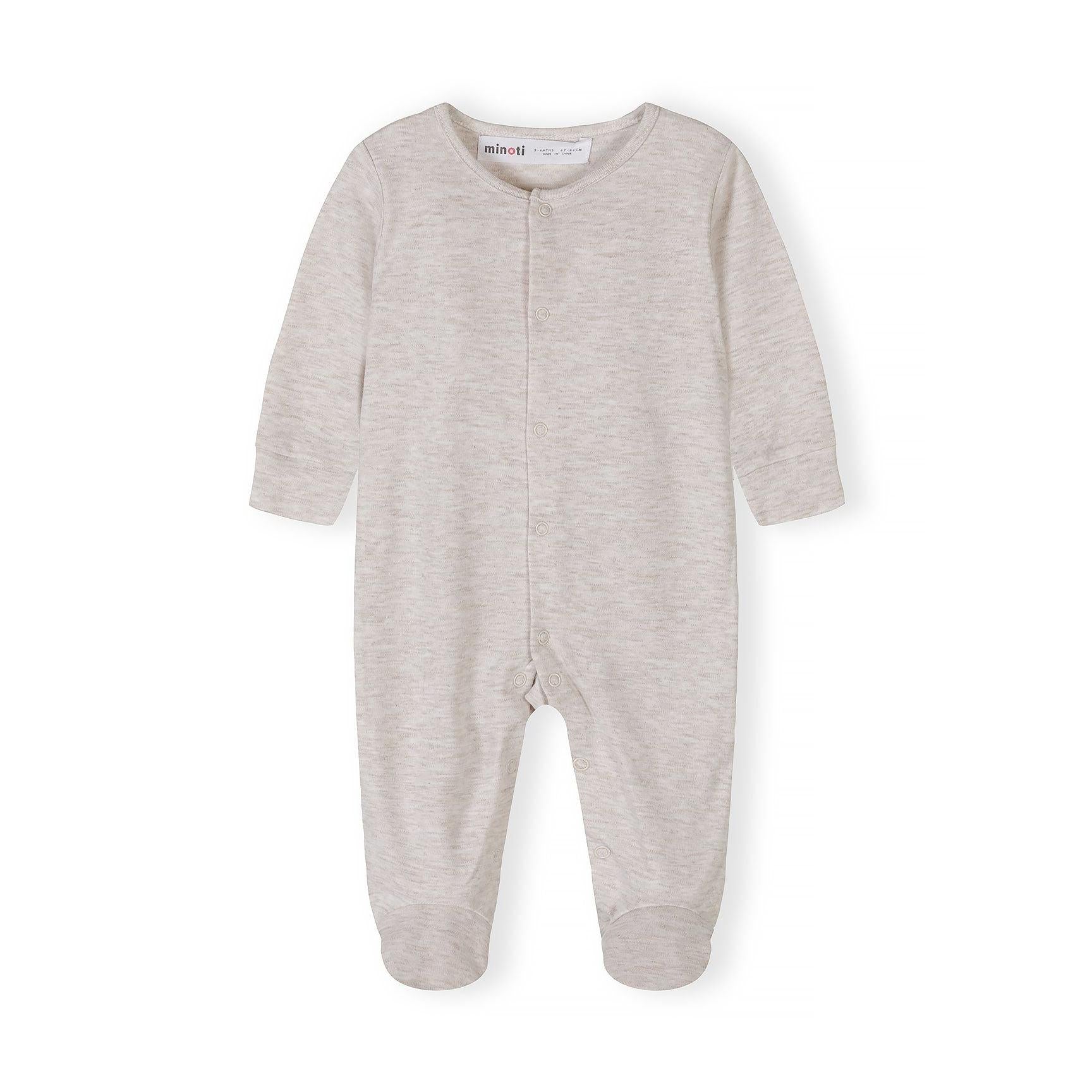 Close-up detail of cream sleepsuit showing Minoti label, snap button closure and soft cotton texture with ribbed neckline