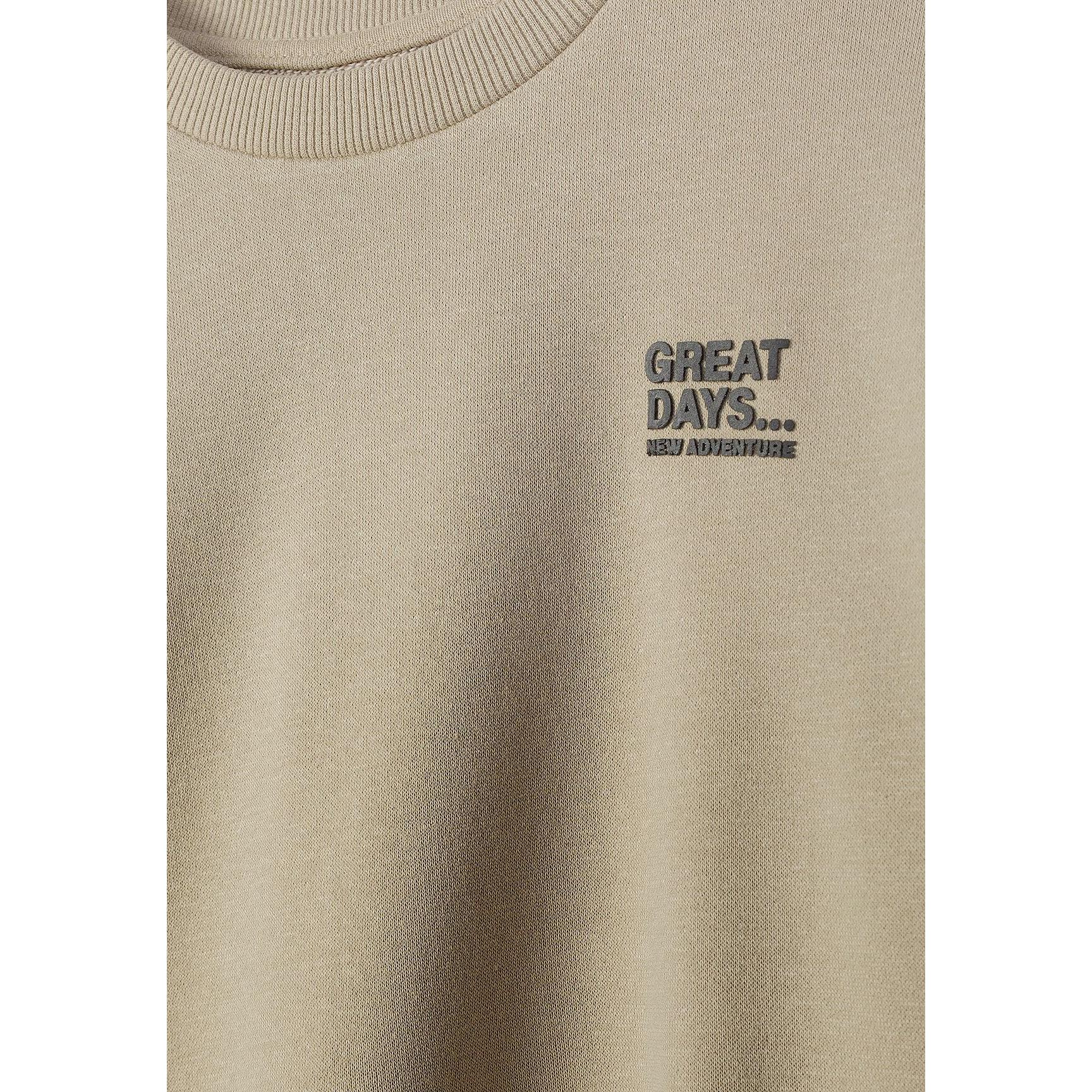 Close-up detail of beige sweatshirt showing Great Days New Adventure text print on chest area