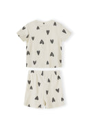 Single cream ribbed pyjama set with black hearts print showing short-sleeved top and matching shorts laid flat on white background