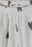 Close-up detail of cream ribbed fabric texture showing hand-drawn black hearts print pattern and crew neckline