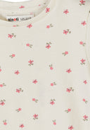 Detail view of pink ribbed fabric texture showing delicate floral print pattern and elastic waistband