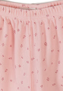 Detail view of pink ribbed fabric texture showing delicate floral print pattern and elastic waistband