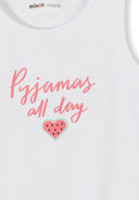 Close-up detail of pink elastic waistband shorts with watermelon heart pattern print, showing Minoti label and fabric texture