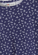 Close-up detail of white ribbed fabric with navy floral print pattern showing Minoti brand label