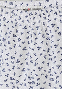 Close-up detail of white ribbed fabric with navy floral print pattern showing Minoti brand label