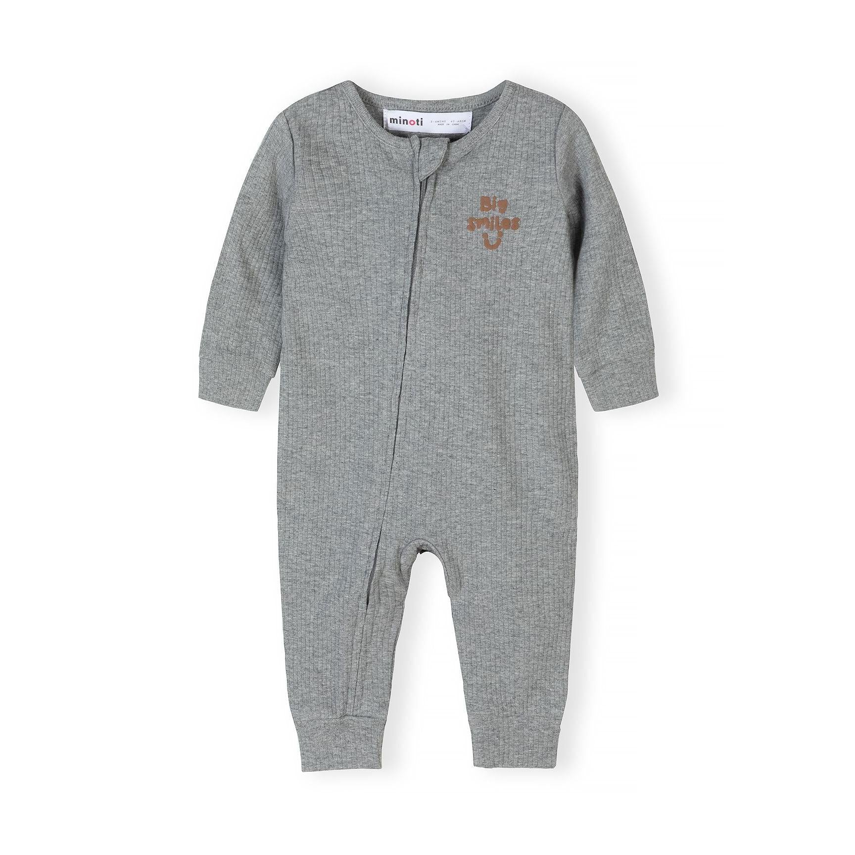 Close-up view of beige polka dot romper with Minoti label showing rib knit texture and front zip detail