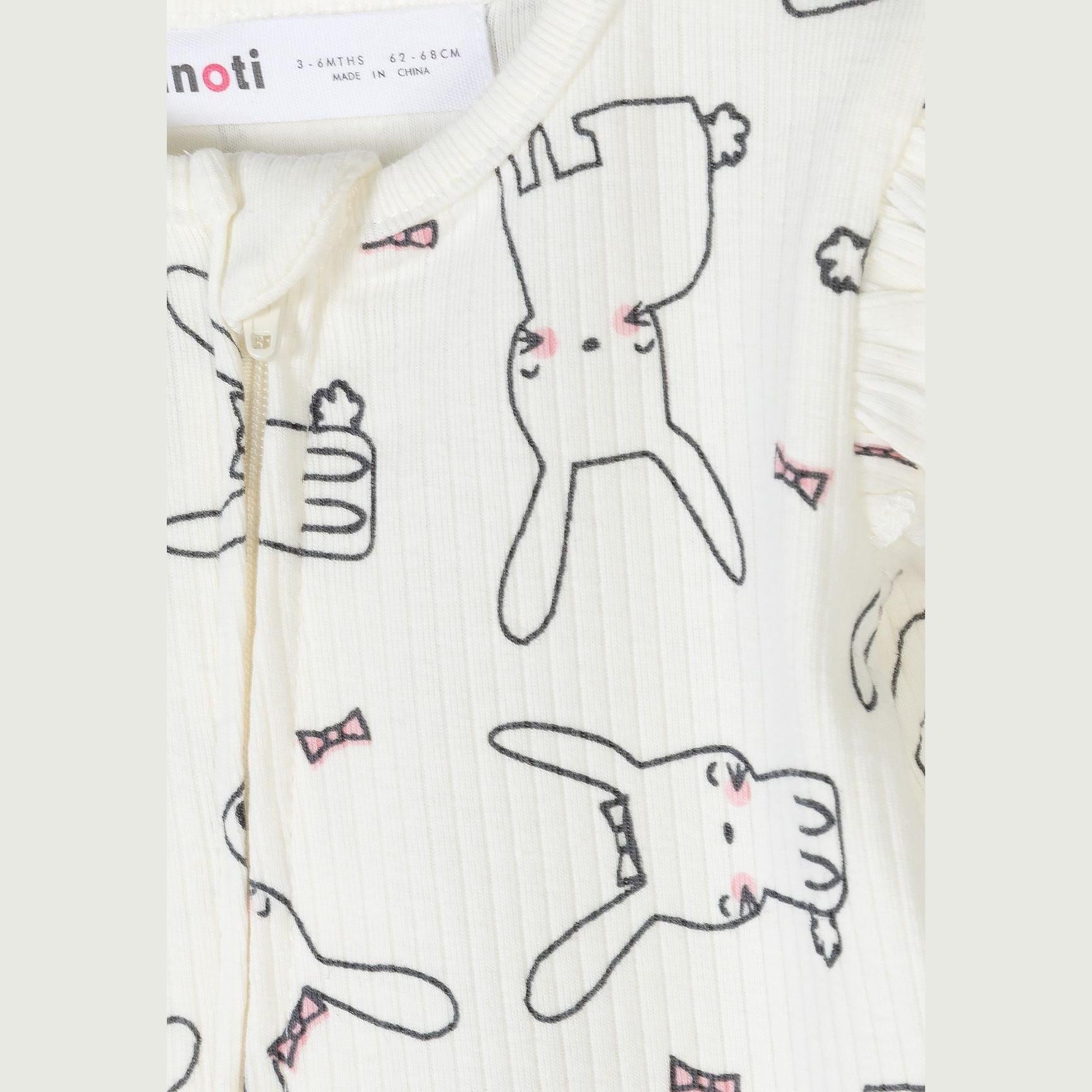 Detail shot of cream sleepsuit fabric showing hand-drawn bunny illustrations with pink bow accents and Minoti label