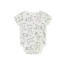 Close-up detail of white bodysuit showing Minoti label and cute rabbit illustrations with pink bow ties