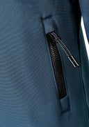 Detail of boys' teal softshell jacket with zippered pocket.