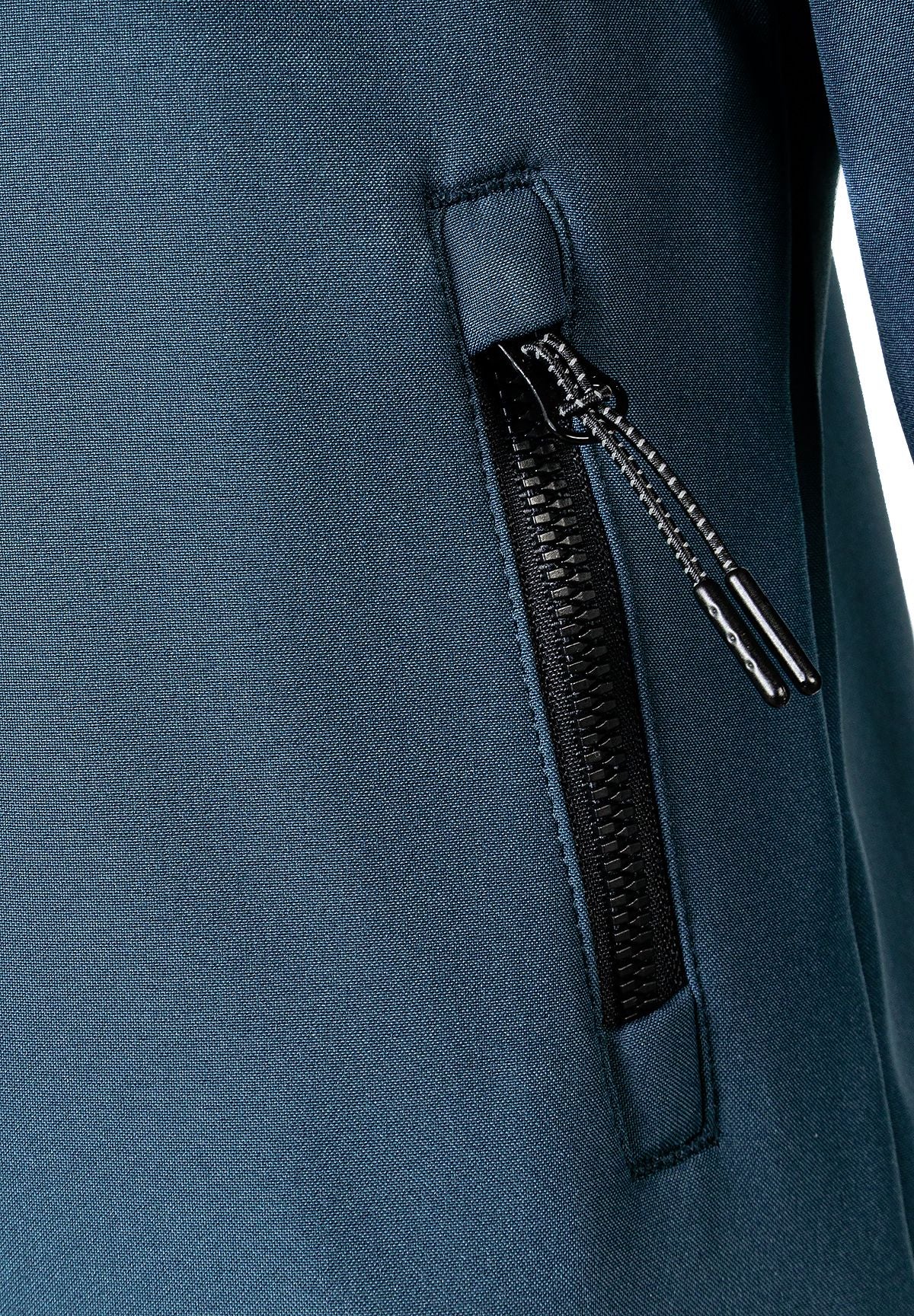 Close-up of the zipped pocket on the teal hooded jacket.
