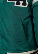 Detail of a boys' blue varsity bomber jacket with snap fasteners and side pocket.