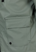 Detail of a boys waterproof parka showing a zipped chest pocket.