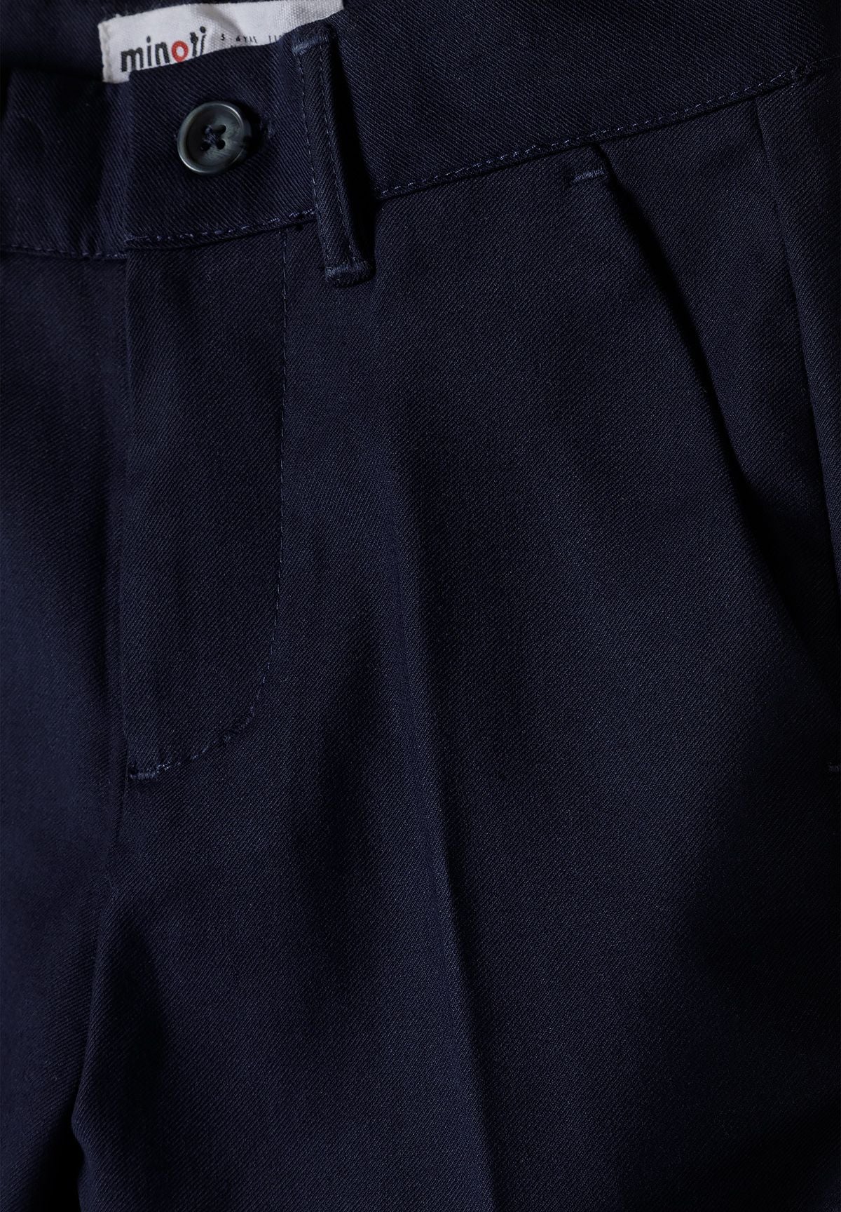 Navy suit trousers, waist button, belt loop and side pocket.