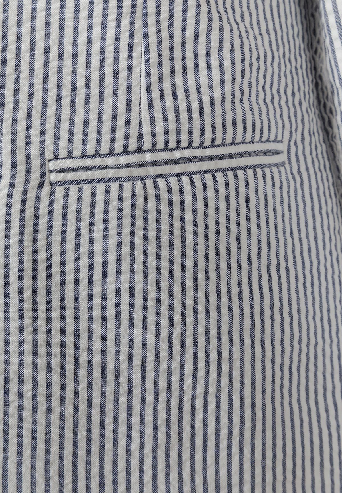 Detail of a boys' navy blue striped tailored blazer with a functional pocket.