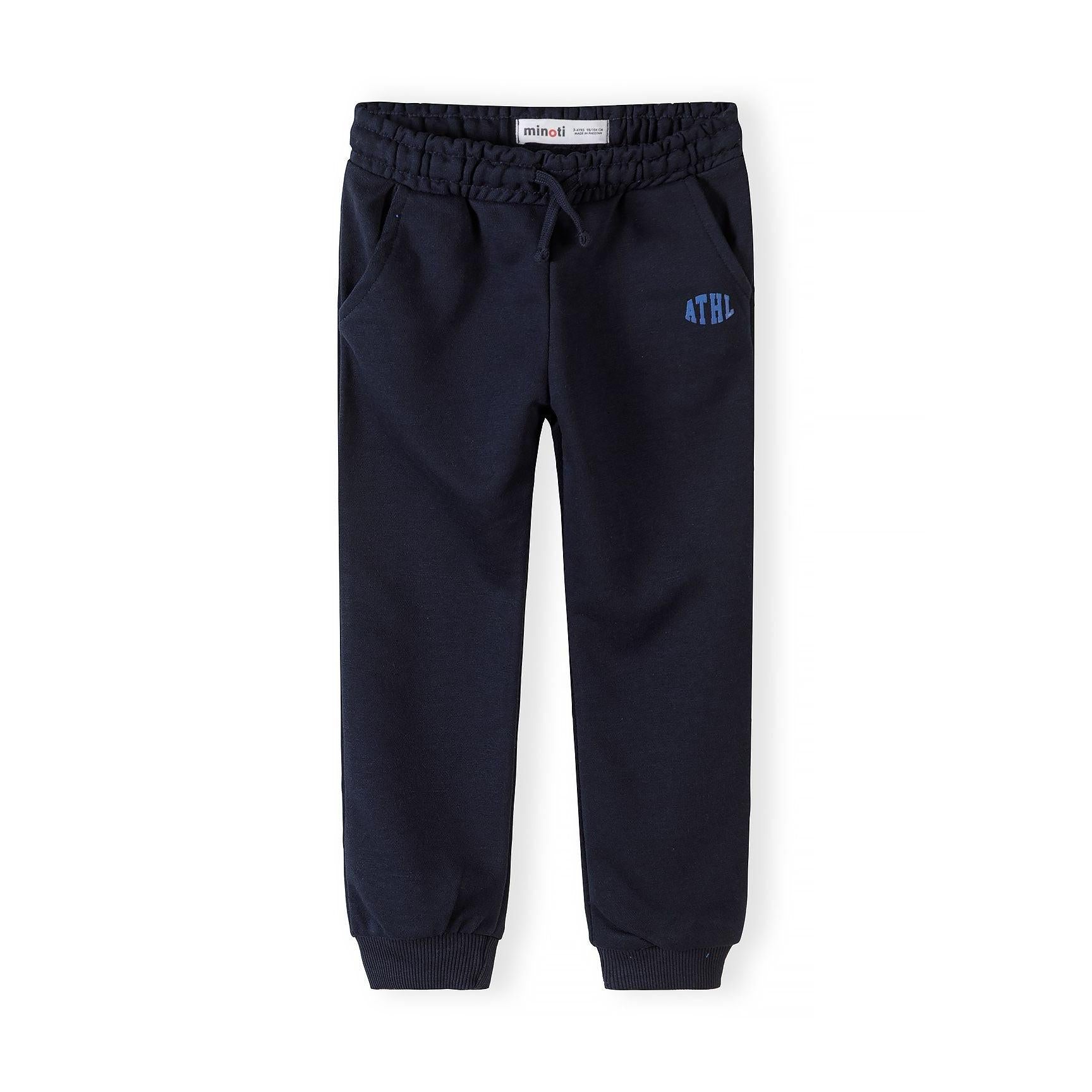 Single navy joggers laid flat showing full silhouette with elastic waist, side pockets and ribbed ankle cuffs against white background