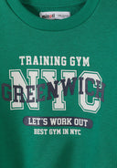 Close-up of green boys sweatshirt with sports-themed printed design featuring NYC and workout text.