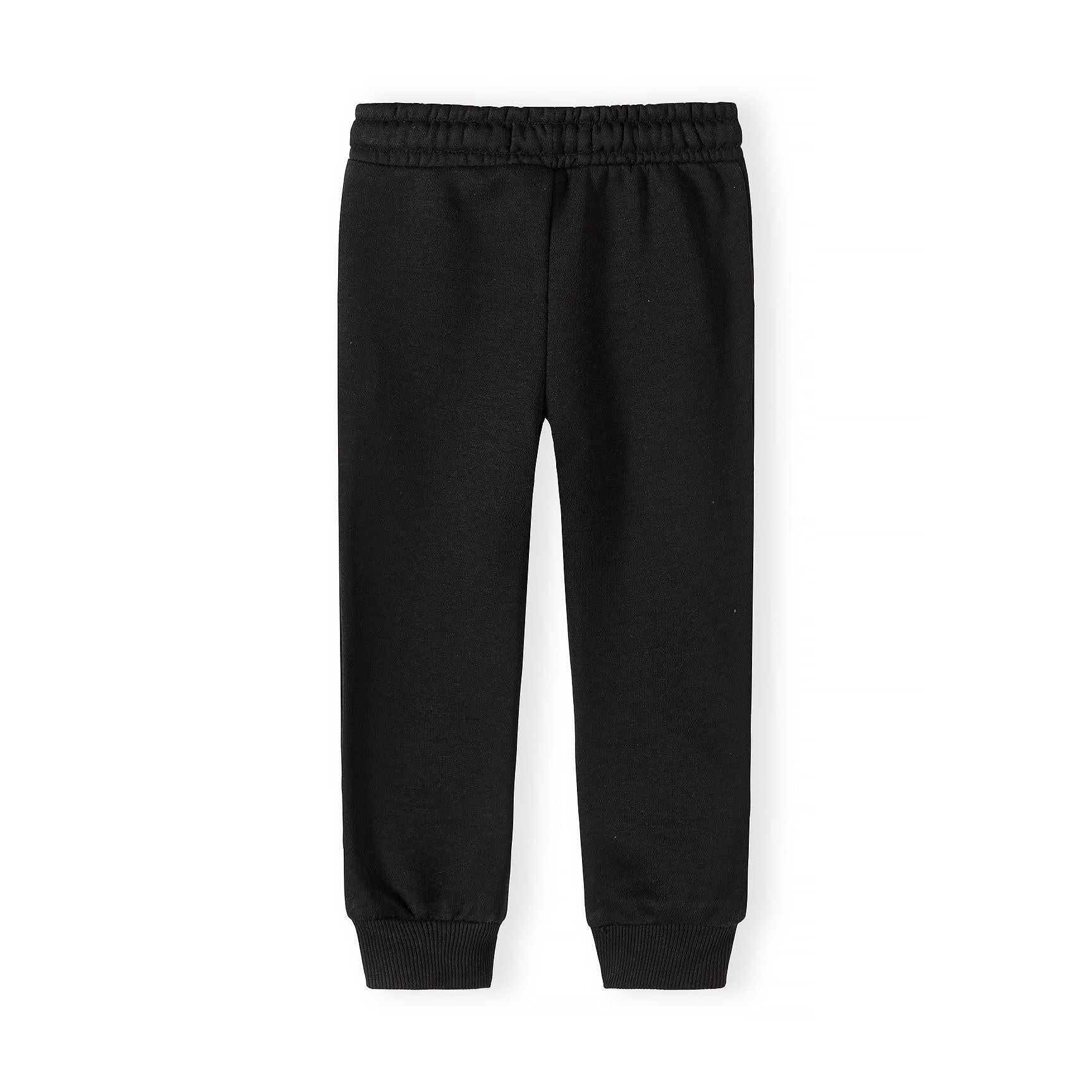 Close-up detail of black joggers showing Minoti label, drawstring elastic waistband and white ATHL lettering on the leg