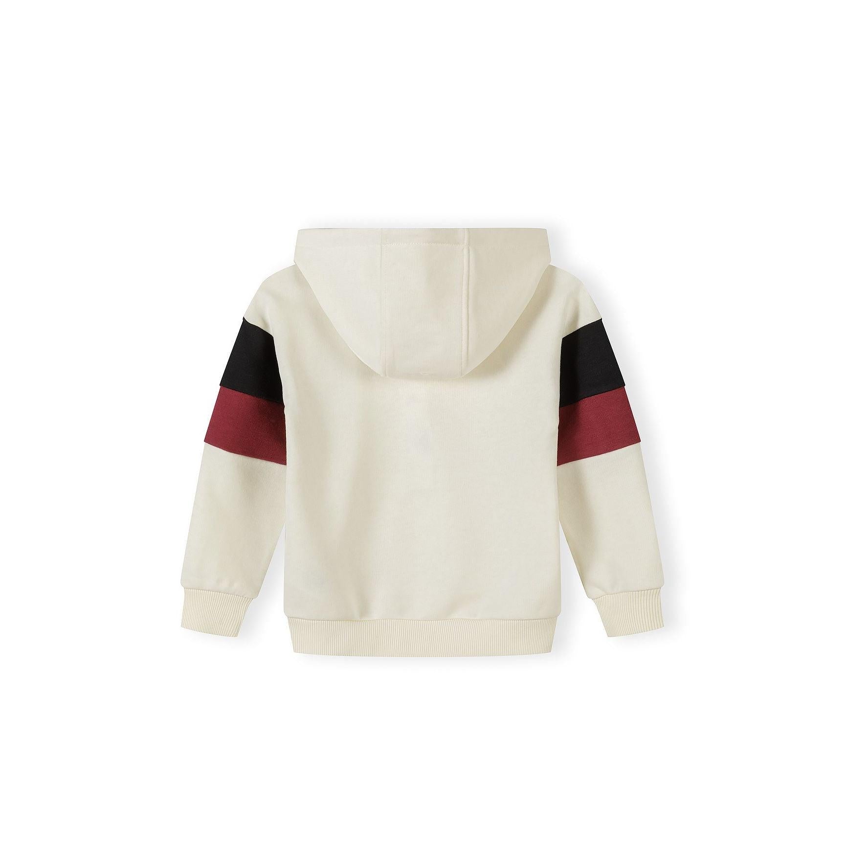 Detail shot of cream hooded sweatshirt showing black branded patch reading 'Unlimited Collective' and black contrast panel on sleeve