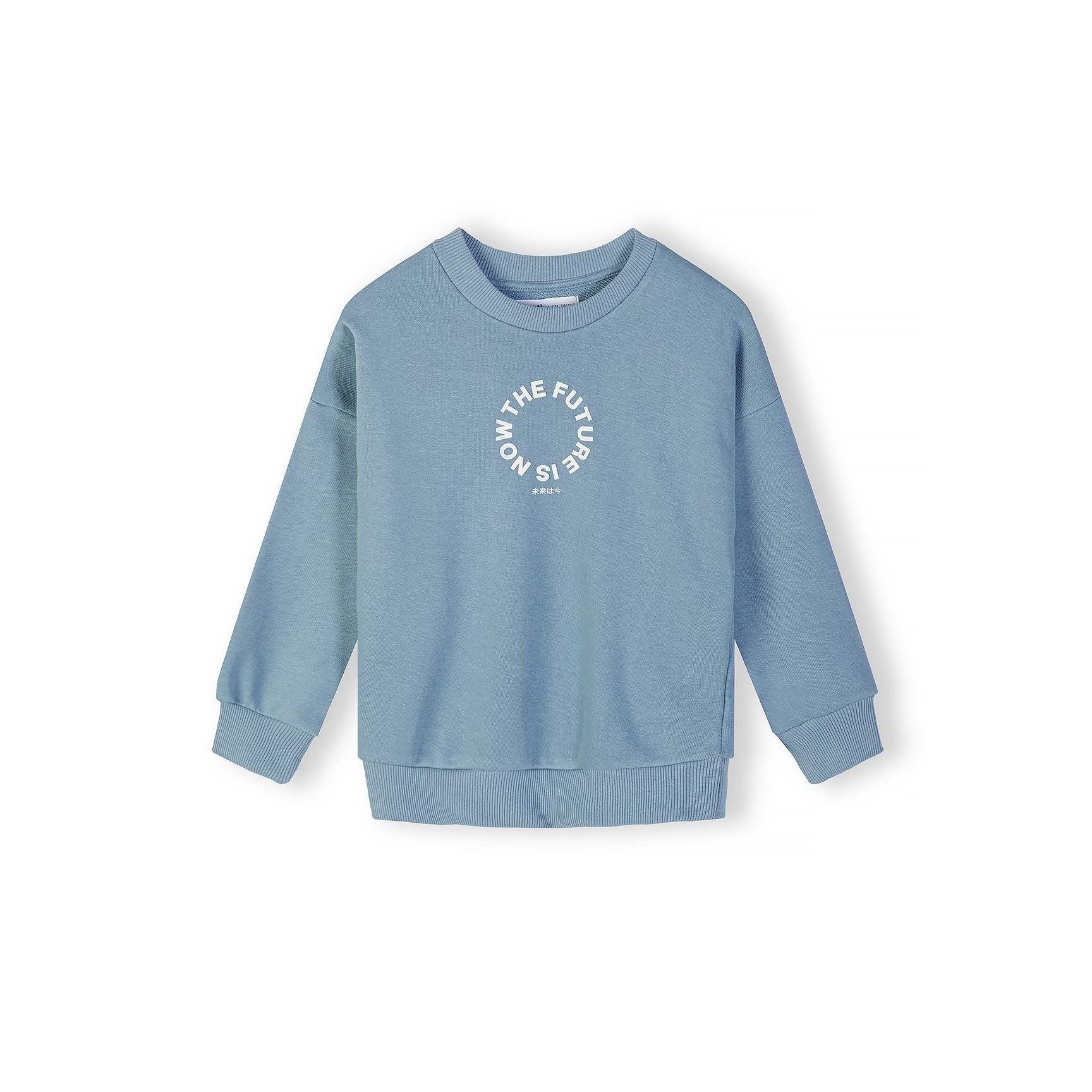 Close-up detail of front chest area showing circular 'The Future is Now' text print with Japanese characters on blue grey fabric