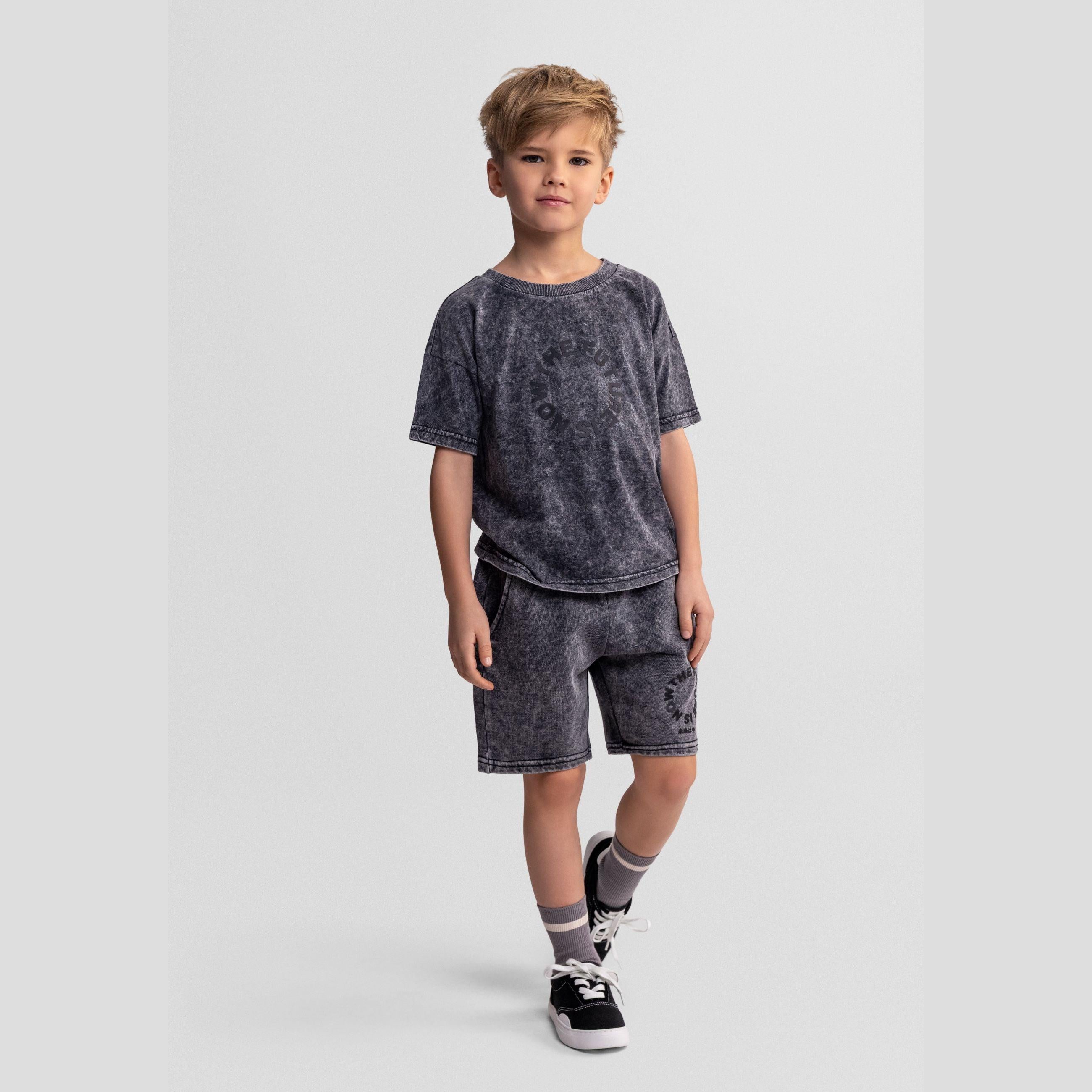 Boy wearing grey acid wash t-shirt and shorts set, standing on white background, full body view showing complete outfit styling
