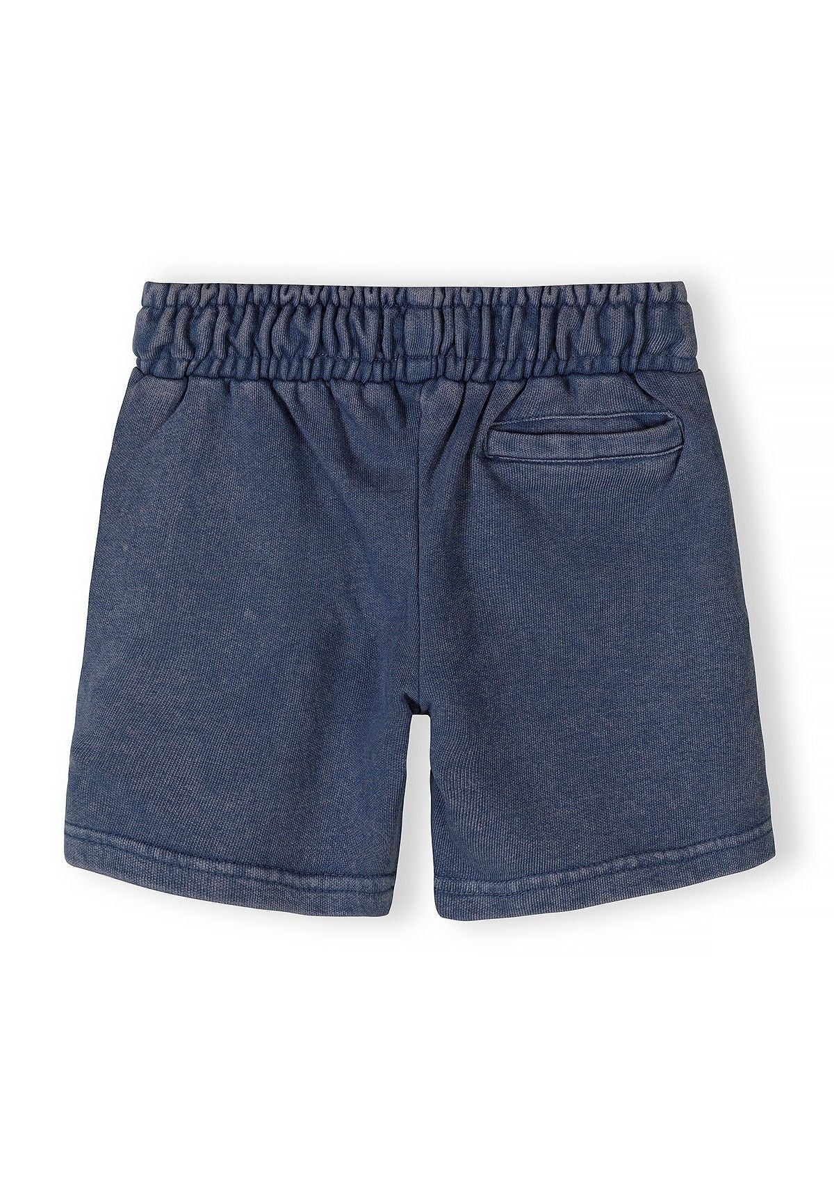 Detail of boys' blue acid wash shorts with elastic waistband and side pocket.