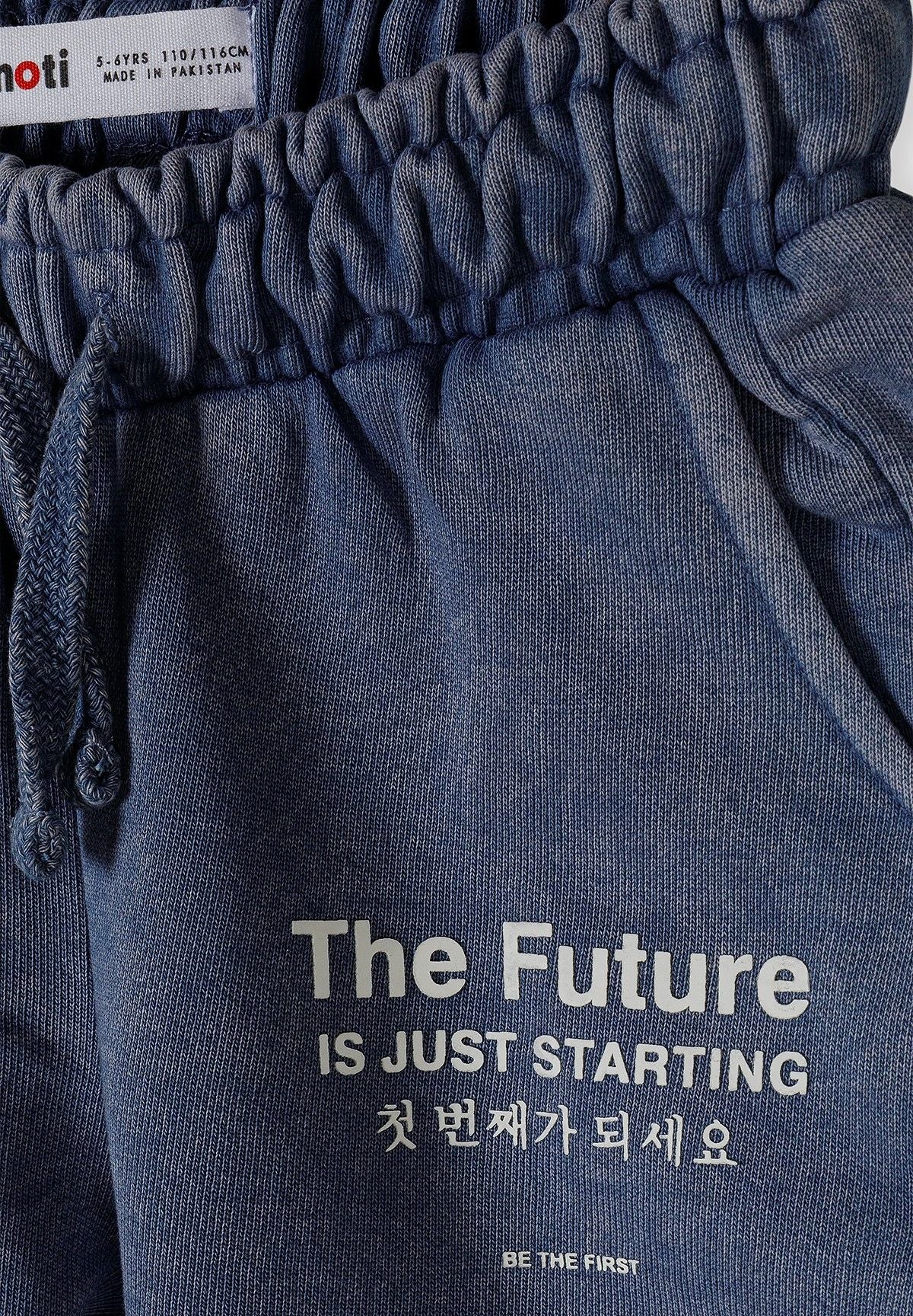 Close-up of blue shorts with elastic waistband and printed text.